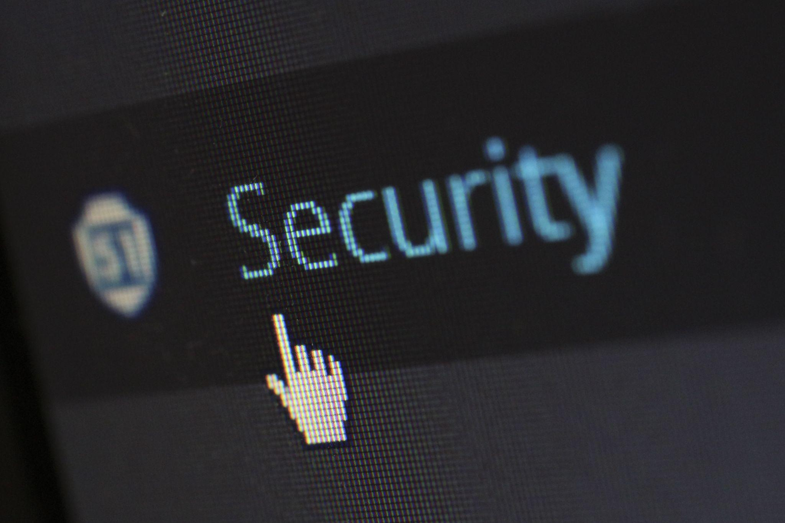 Close-up image of a computer screen with the word "Security" highlighted in light blue and a cursor icon resembling a pointing hand positioned nearby.