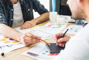 businessman dictating notes to his colleague in office
