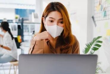 asia businesswoman wear face mask for social distancing in new normal situation for virus prevention while work office