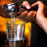 person pouring water on clear drinking glass, Easily-Remove-Dark-Spots-Lemon-Juice