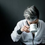 woman holding mug in drinking gesture, Know-The-Causes-Of-White-Hair-And-Easy-Ways-To-Prevent-It-Naturally