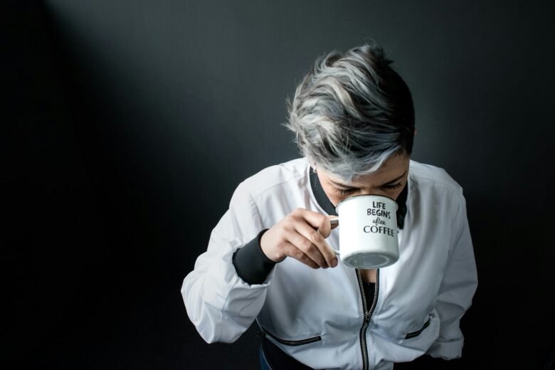 woman holding mug in drinking gesture, Know-The-Causes-Of-White-Hair-And-Easy-Ways-To-Prevent-It-Naturally