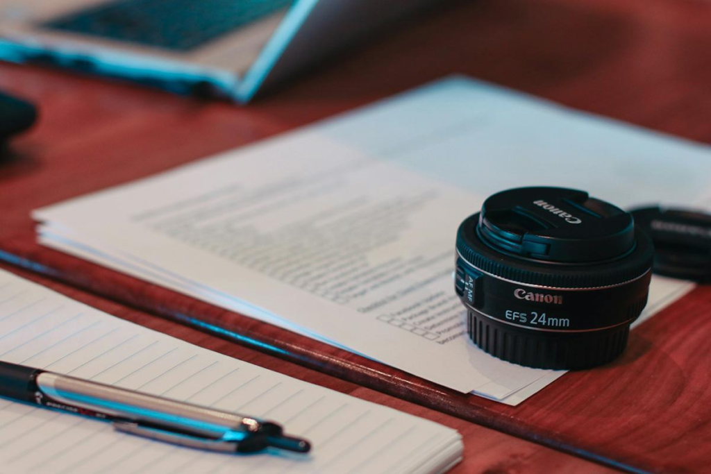 camera lens, pen, table, papar