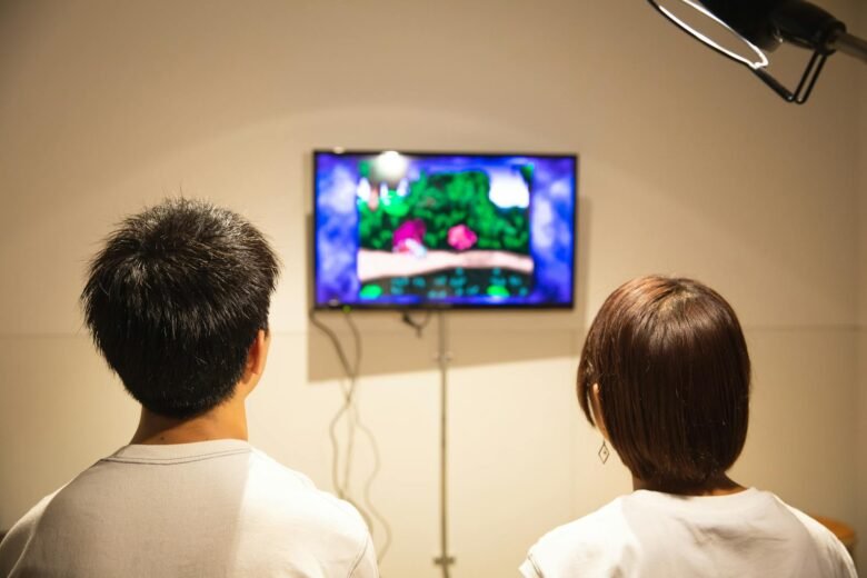 A couple playing a video game together on a television in a cozy indoor setting.