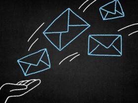 A chalk drawing on a black background shows a hand tossing four envelope icons, symbolizing emails. Three envelopes are blue and outlined in white, while the fourth is purely white. Curved lines indicate they are in motion.