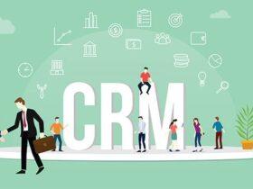 Illustration of people interacting around large "CRM" letters on a platform. Two men in suits shake hands on the left, while others talk, use laptops, and stand on the letters. Various icons related to finance and communication float above them.