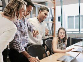 woman sitting and discussing with colleagues at office table