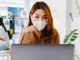 asia businesswoman wear face mask for social distancing in new normal situation for virus prevention while work office