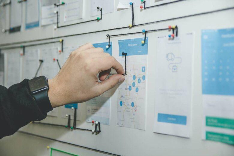 person working on blue and white paper on board,Stakeholder Mapping