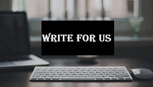 A sleek white keyboard is situated on a dark desk with a blurred background of a window and a computer screen. In the center of the image, a black rectangle with white text reads "WRITE FOR US" in bold, stylized font.