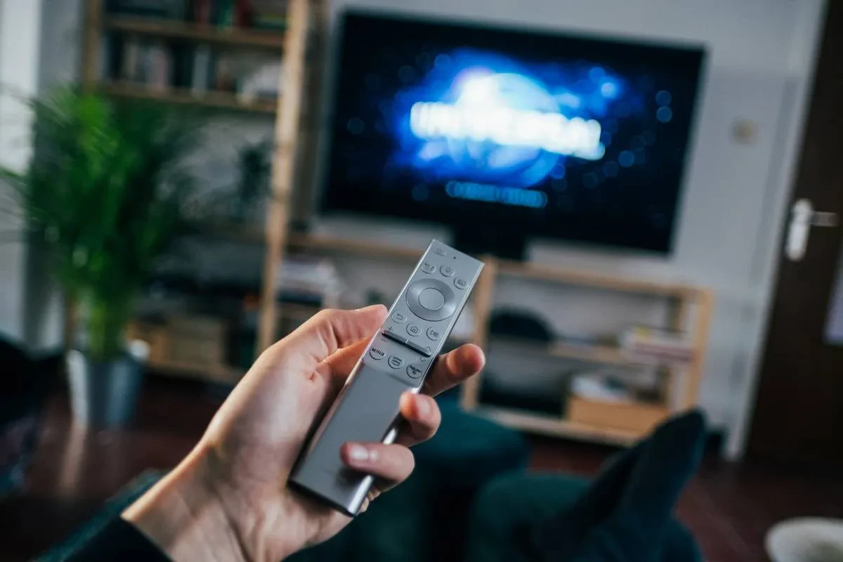person holding gray remote control, Television Commercial Company