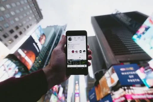 mobile on hand with building background