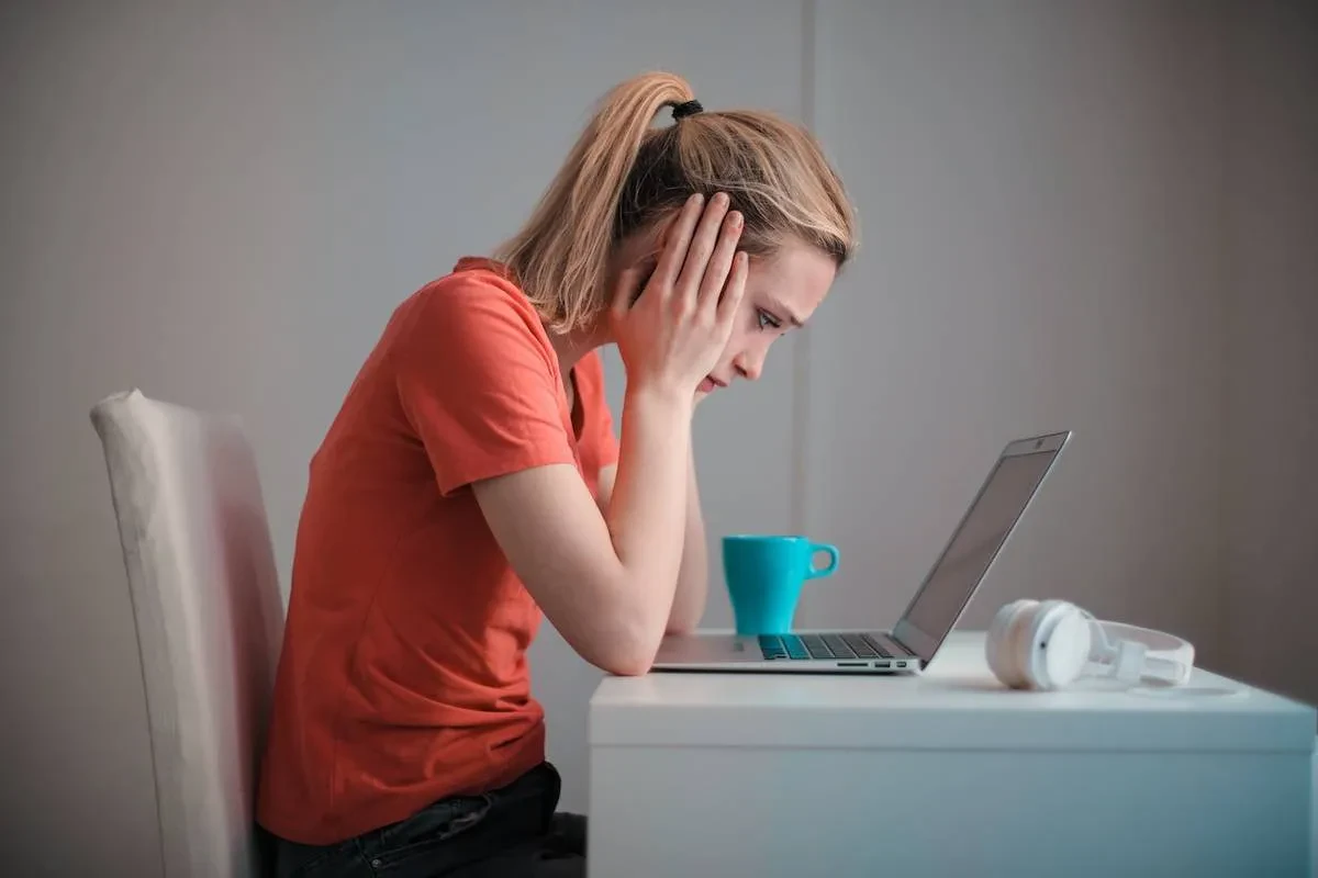 Young troubled woman using laptop