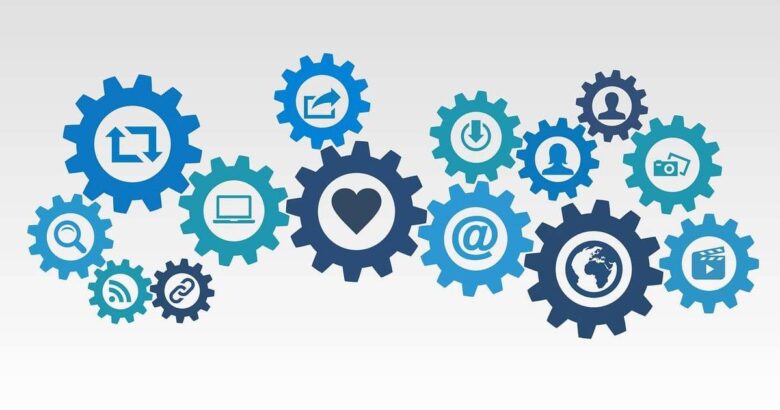 Graphic of interlocking gears with various technology and communication icons, including a heart, world, email, power button, and user profiles, symbolizing interconnected digital interactions.