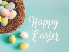 A nest filled with colorful Easter eggs is on the left side of the image, with three more eggs outside the nest. "Happy Easter" is written in white cursive text on the right side against a light blue background.