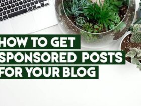 Image showing a white desk with a laptop, eyeglasses, a camera lens, and various potted plants, including succulents and cacti. The text on the image reads "HOW TO GET SPONSORED POSTS FOR YOUR BLOG" in bold green lettering.