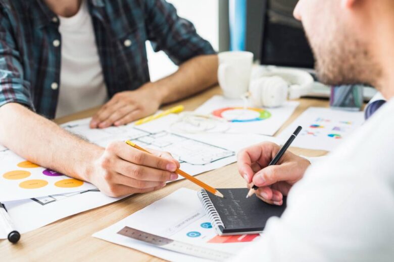 businessman dictating notes to his colleague in office