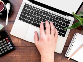 person's hand typing on laptop