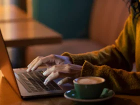 sideways woman working on her laptop in a coffee shop
