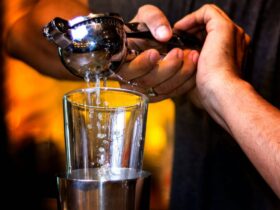 person pouring water on clear drinking glass, Easily-Remove-Dark-Spots-Lemon-Juice