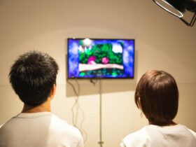 A couple playing a video game together on a television in a cozy indoor setting.