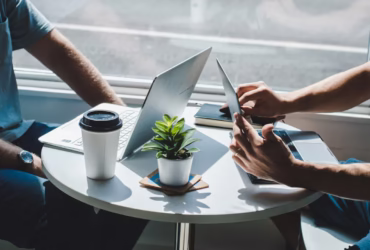 a person sitting at a table with a laptop